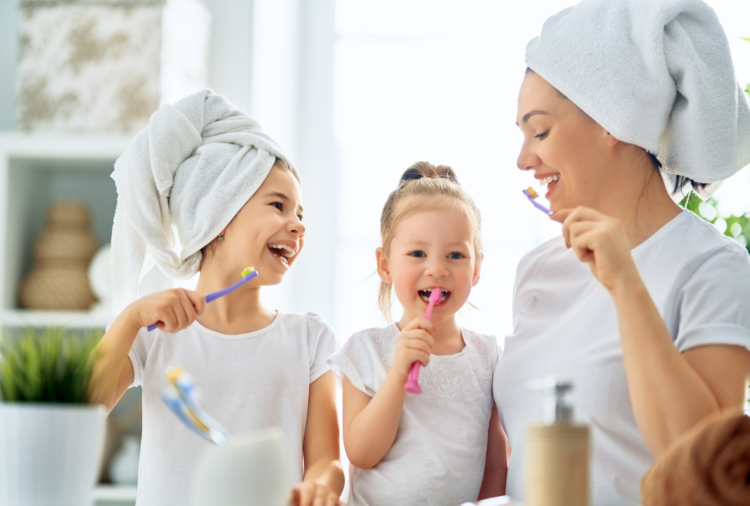 moeder en kinderen die samen tandenpoetsen 